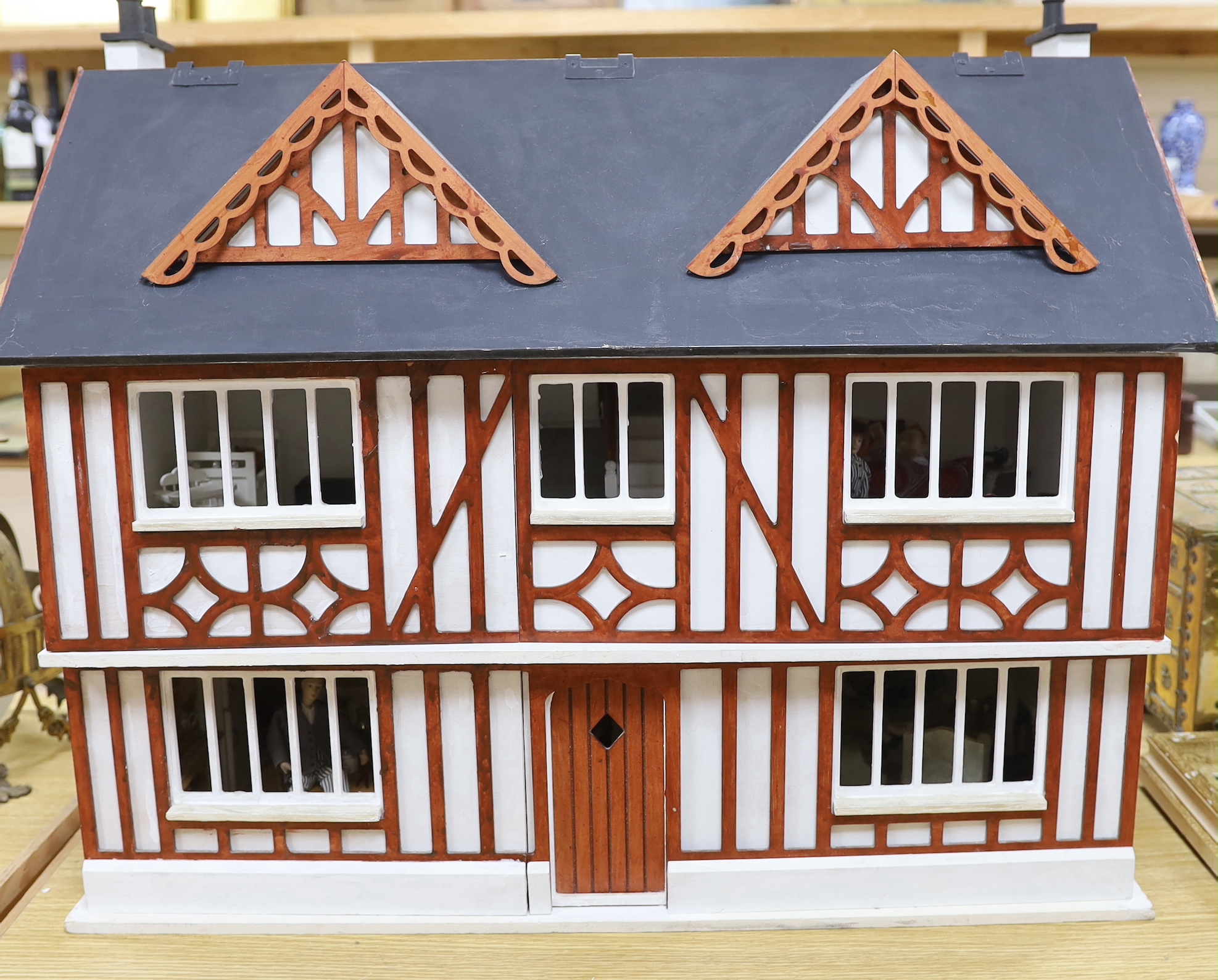 A painted doll's house with dolls and furniture, dolls house 78.5cm wide, 67cm high